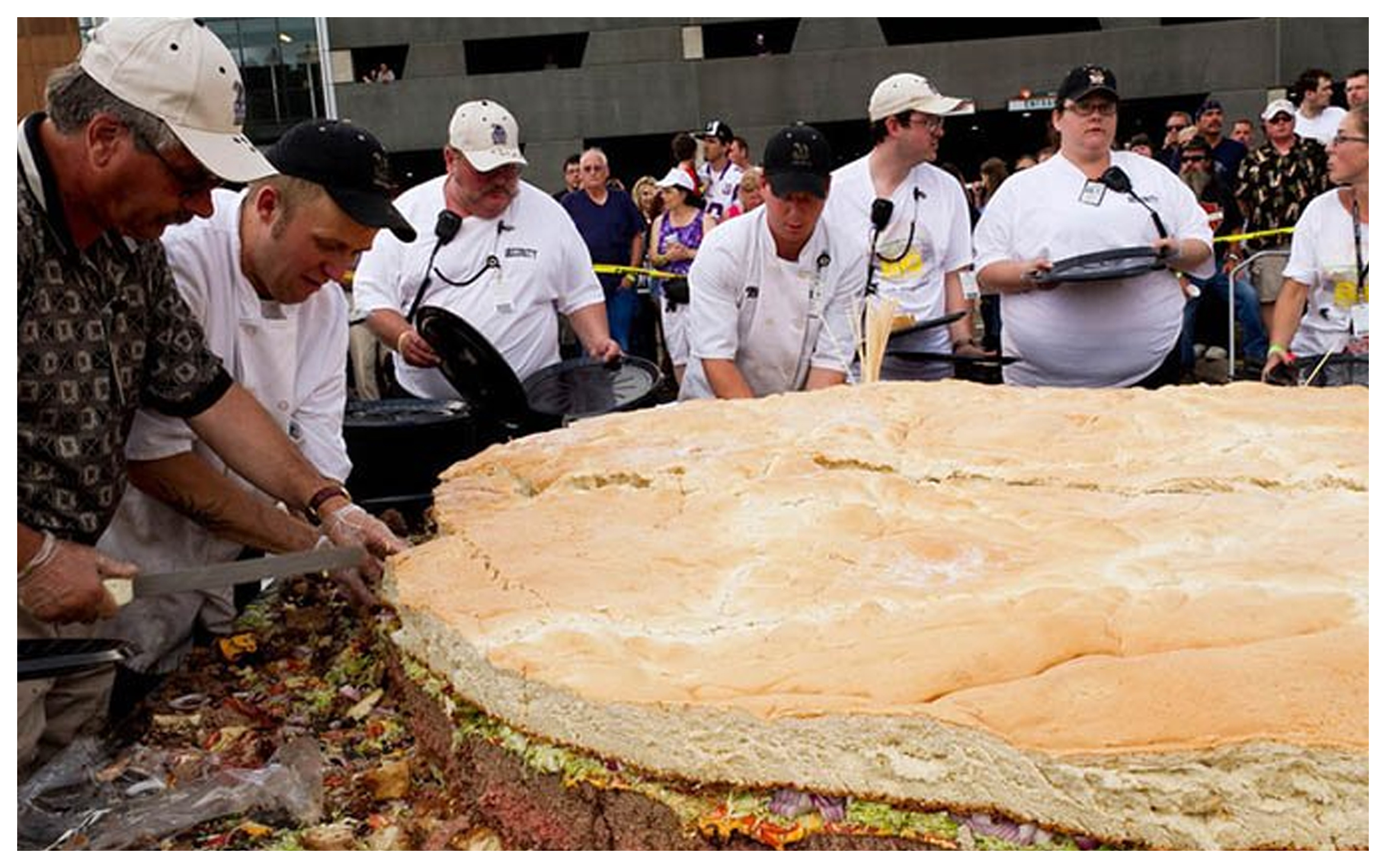 С неба падает гигантская еда название. Самый большой бургер. Самый большой гамбургер в мире. Самый большой бутерброд. Огромная еда.